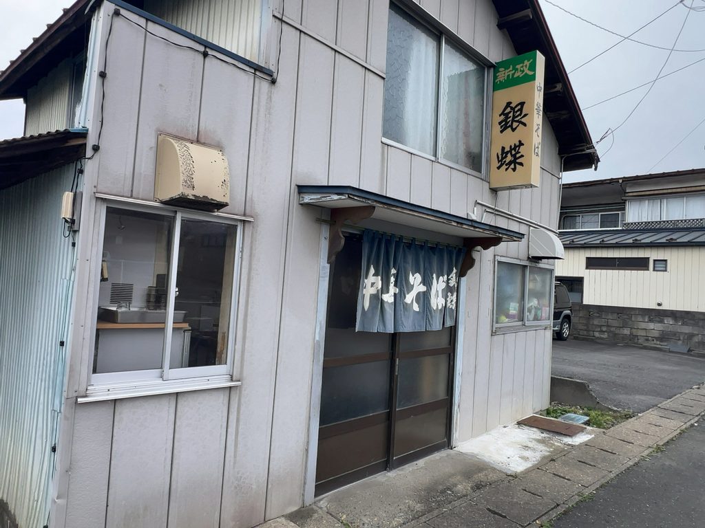 藍色の暖簾と看板が印象的な「中華そば 銀蝶」の店舗外観