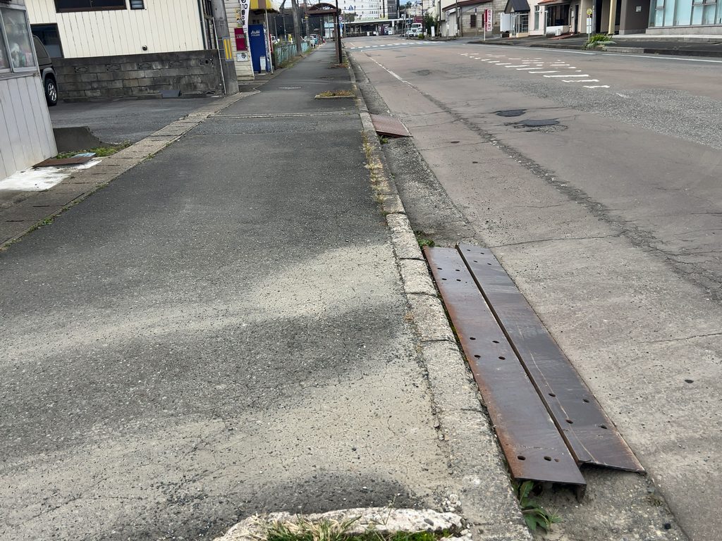 「中華そば 銀蝶」の敷地入口付近にある歩道沿いの鉄板と段差の様子