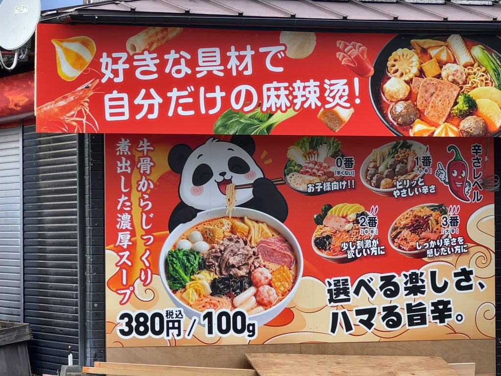 「好きな具材で自分だけの麻辣烫！」と辛さレベルが書かれた「七々麻辣烫」の看板ポスター