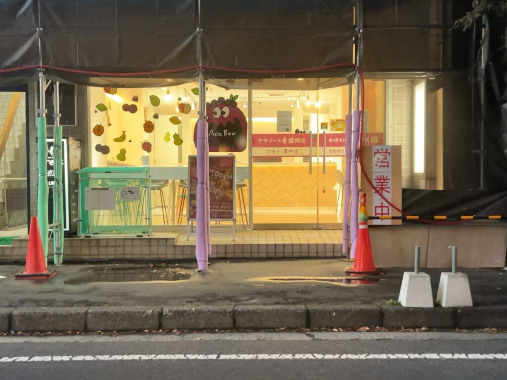 「アサイー工房 盛岡店」のピンクの看板とキャラクター「Aca Bow」が描かれた明るい店先