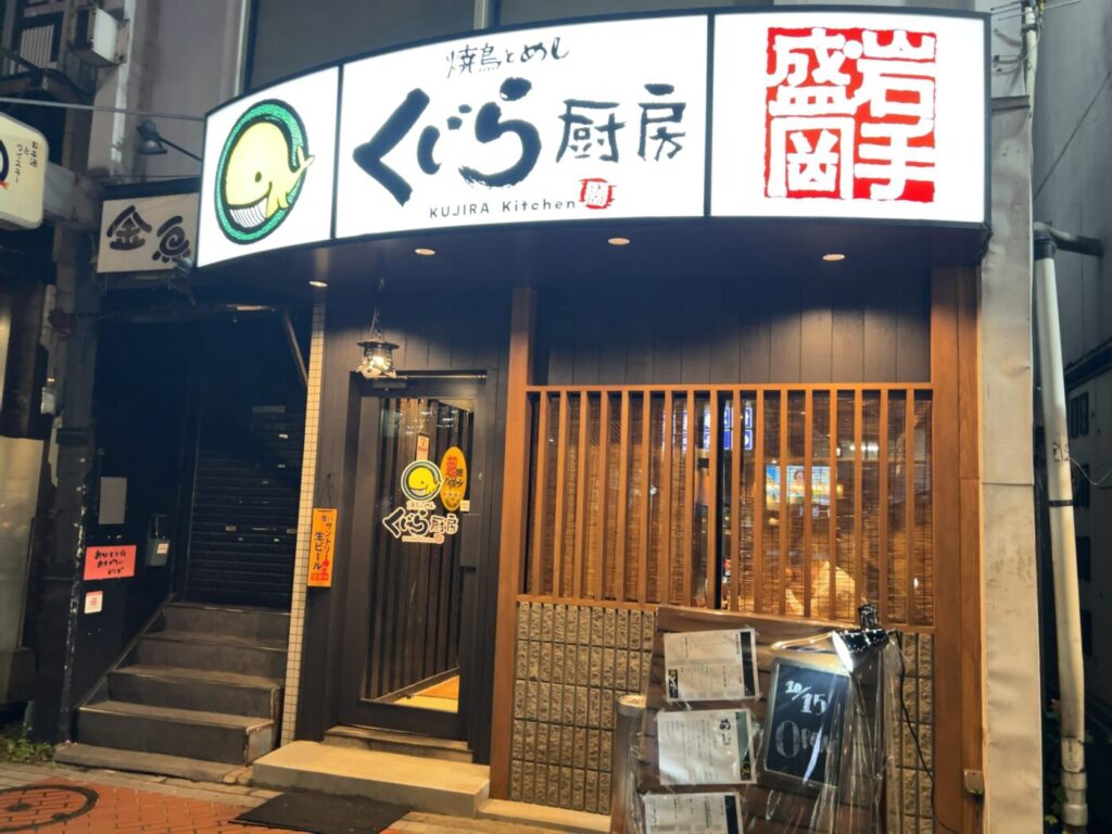 焼鳥とめし くじら厨房の夜の外観。入口横の黒板に「10/15 OPEN」と書かれている