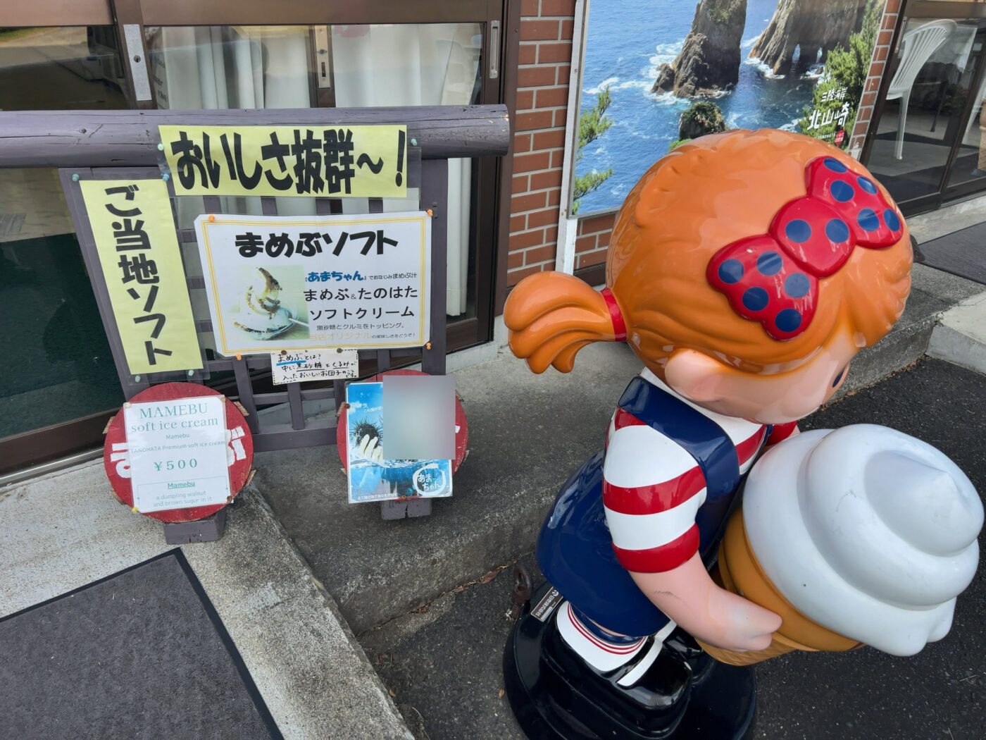 北山崎レストハウスのまめぶソフトの案内と、ソフトクリームを抱えた女の子の像