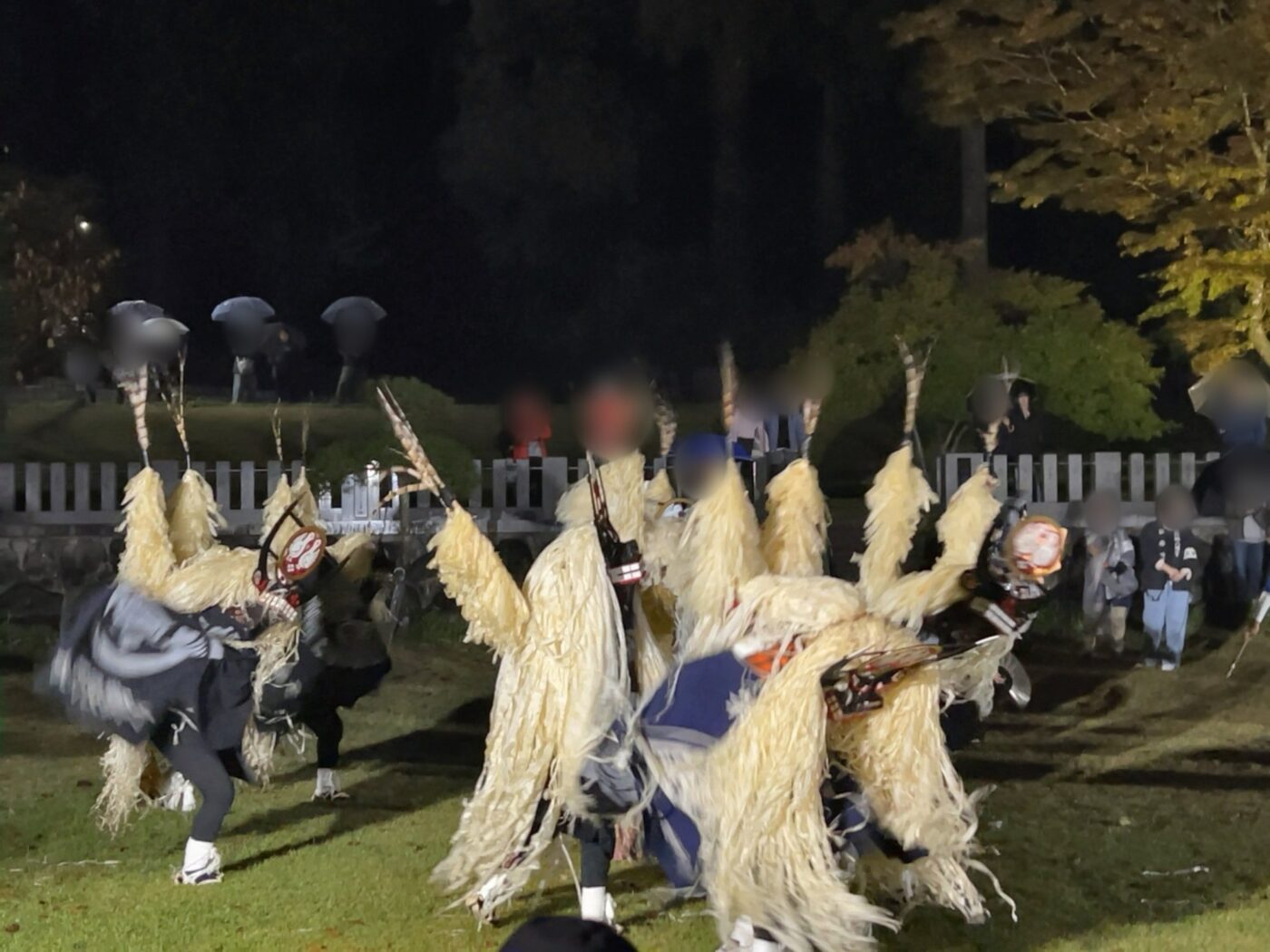 遠野郷八幡宮のしし踊りと、傘をさして見守る人たち