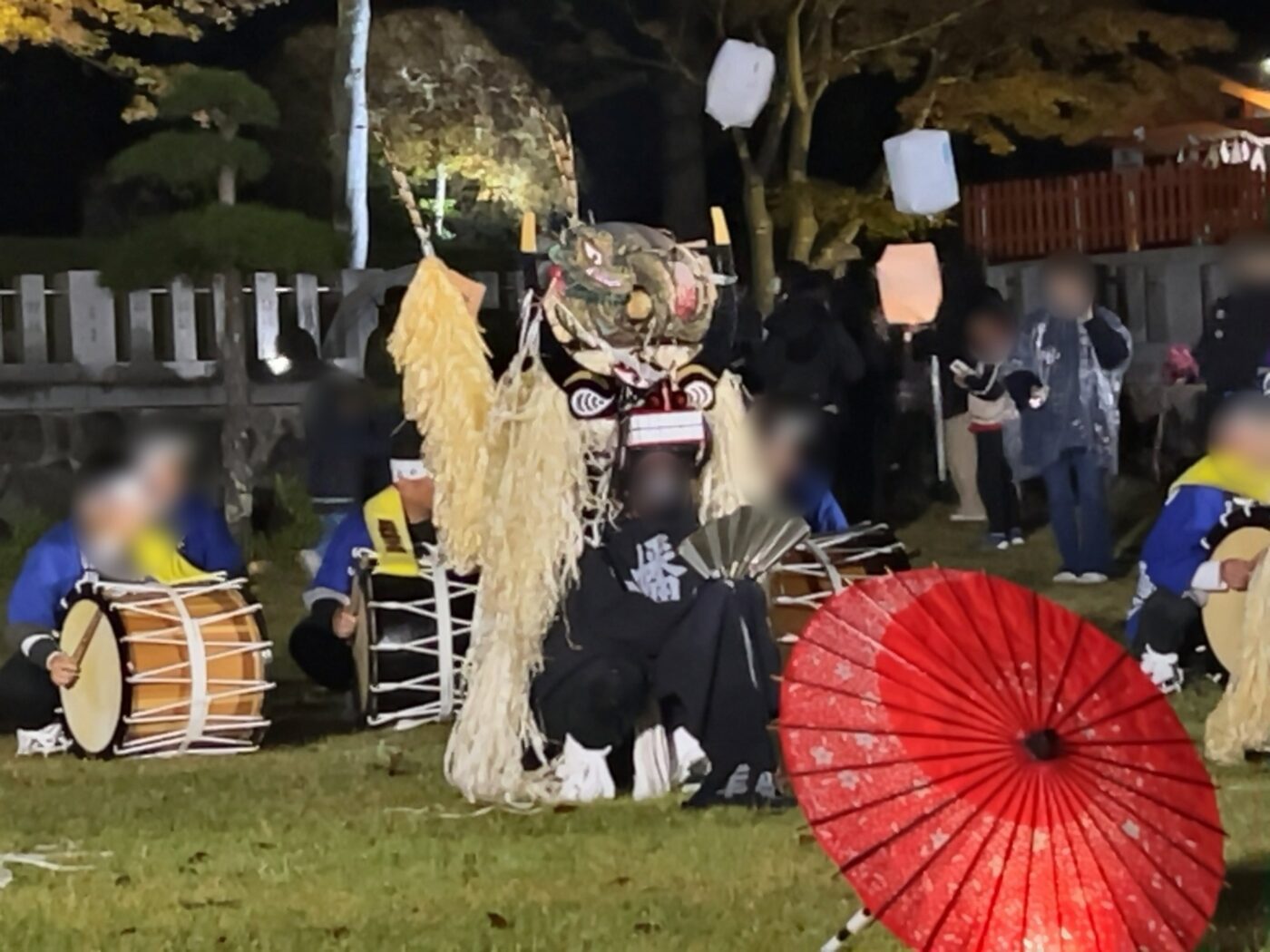 遠野郷八幡宮のしし踊り。赤い和傘の向こうで太鼓とししが座る様子