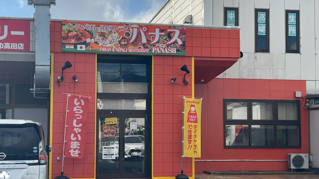 コインランドリーやコンビニと並ぶ「インド&ネパールレストラン パナス」の店舗外観