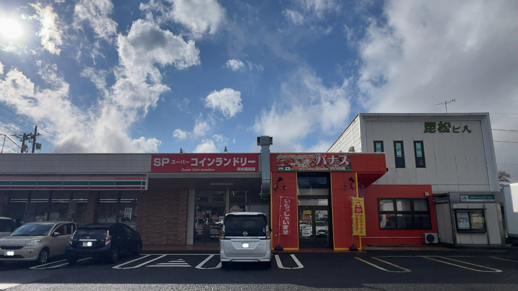 コインランドリーやコンビニと並ぶ「インド&ネパールレストラン パナス」の店舗外観